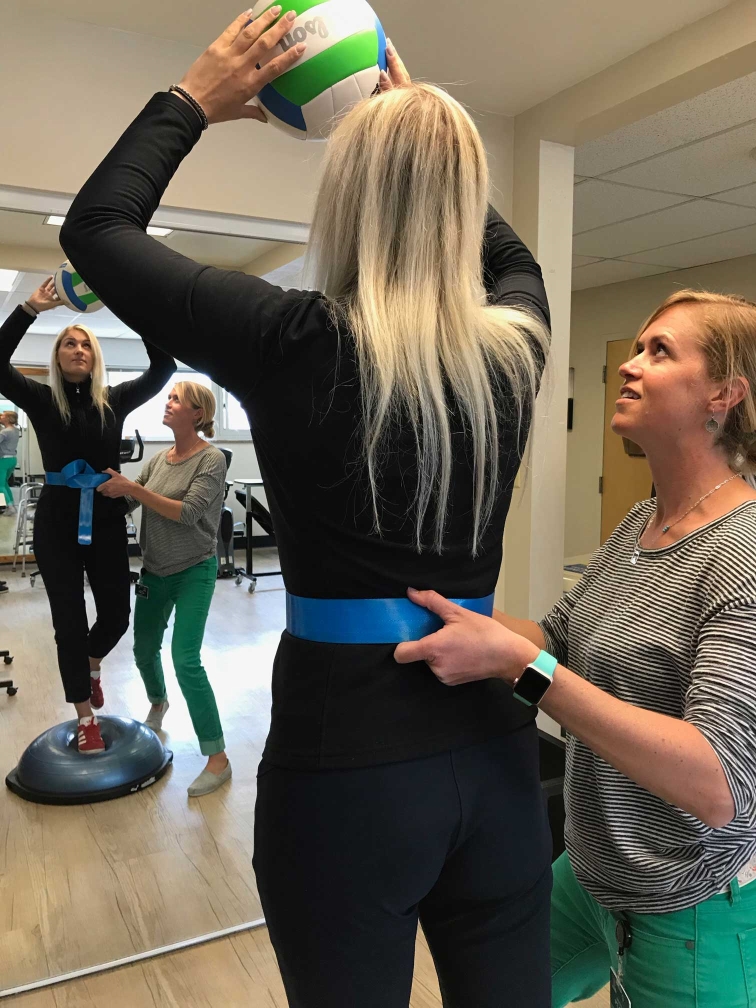 woman holding volleyball for rehab session